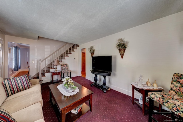 living room featuring baseboards, a textured ceiling, stairs, and carpet floors
