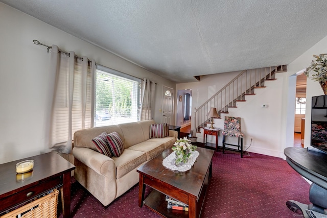 living room with carpet flooring, a textured ceiling, baseboards, and stairway