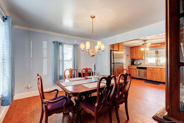 dining room featuring baseboards, ornamental molding, ceiling fan with notable chandelier, and light wood-style flooring