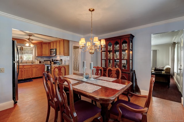dining area featuring baseboards, ornamental molding, ceiling fan with notable chandelier, and light wood finished floors