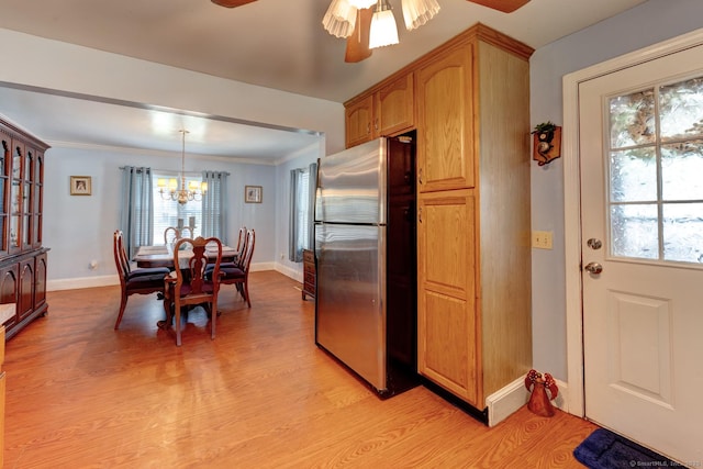 kitchen featuring freestanding refrigerator, baseboards, ceiling fan with notable chandelier, and light wood-style floors