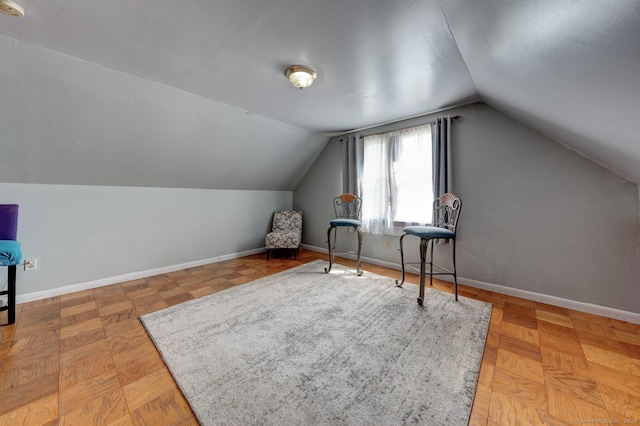 interior space featuring baseboards and lofted ceiling