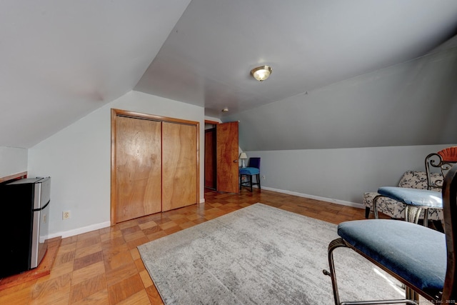 sitting room featuring baseboards and lofted ceiling