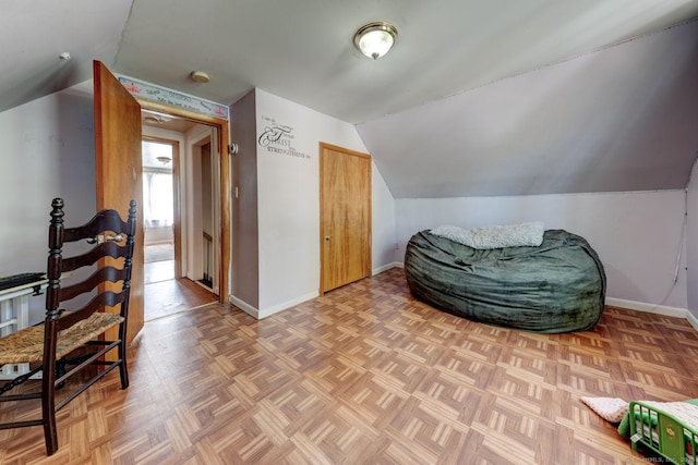 sitting room featuring baseboards and vaulted ceiling