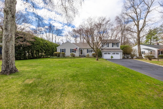 view of front of home with an attached garage, driveway, and a front lawn
