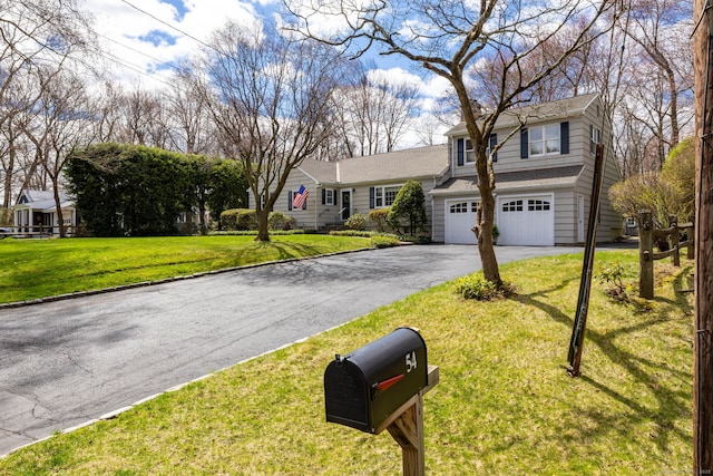 view of front of house featuring driveway, a front yard, and a garage