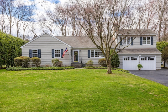traditional-style home with driveway, a shingled roof, a front lawn, and a garage