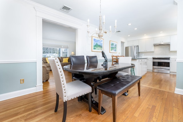 dining room with visible vents, light wood-type flooring, a chandelier, ornamental molding, and recessed lighting