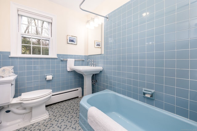 bathroom featuring a tub, tile walls, a baseboard radiator, and toilet