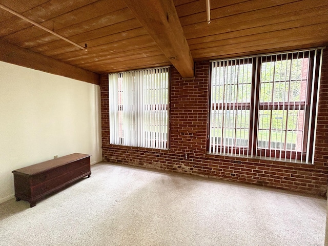 spare room with carpet flooring, wooden ceiling, beamed ceiling, and brick wall