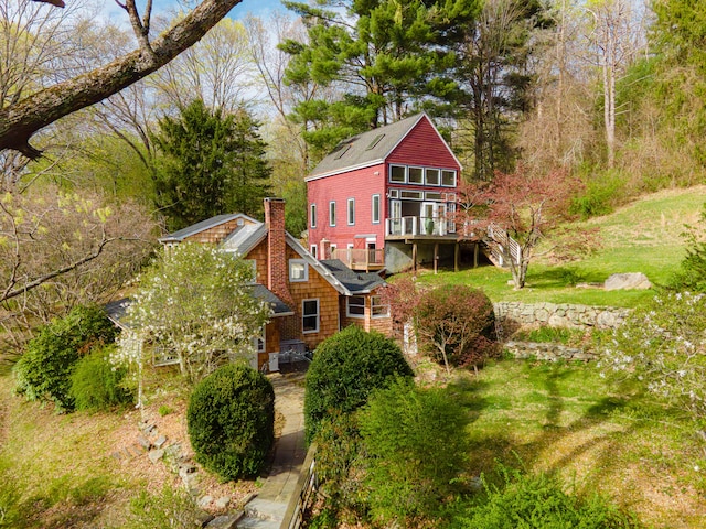 back of property featuring stairs, a wooden deck, and a chimney