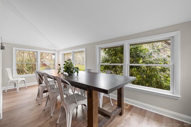 dining room with baseboards, light wood-style floors, and a wealth of natural light