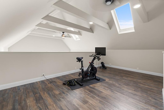exercise area featuring vaulted ceiling with skylight, baseboards, and wood finished floors