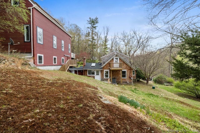 rear view of property featuring a wooden deck and stairs