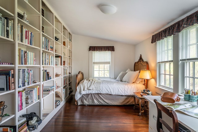 bedroom with wood finished floors and lofted ceiling