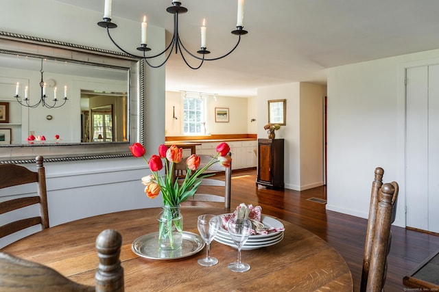 dining room featuring an inviting chandelier, baseboards, and wood finished floors