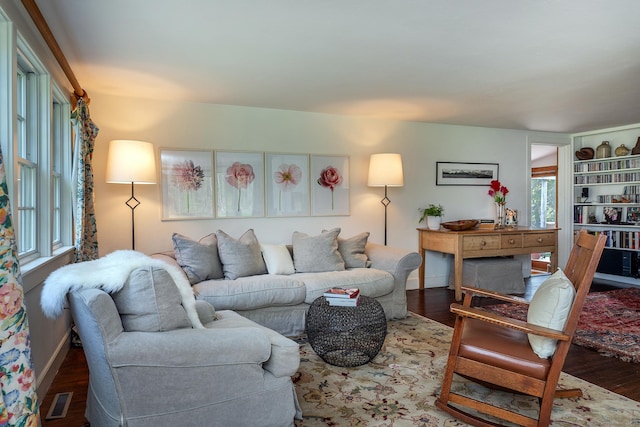 living room with baseboards, wood finished floors, and visible vents