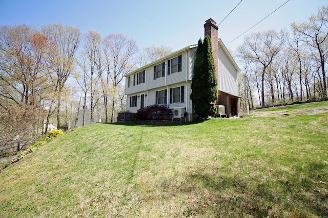 view of side of property with a yard and a chimney