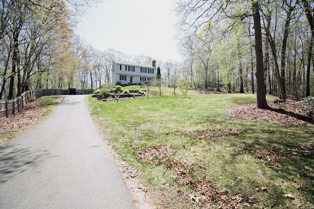 view of street with driveway and a forest view