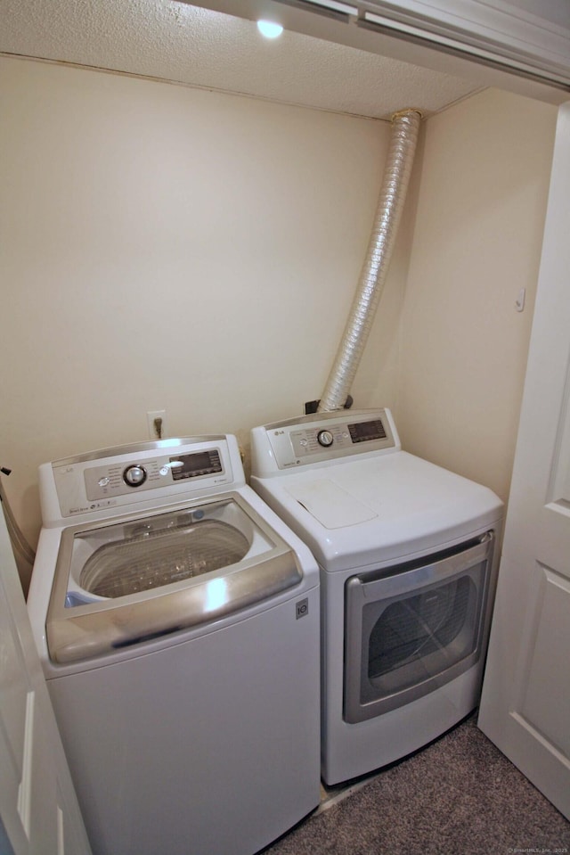 clothes washing area featuring washing machine and clothes dryer, laundry area, and carpet floors