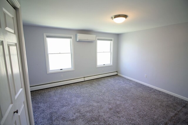 carpeted spare room featuring baseboards, a baseboard heating unit, and an AC wall unit