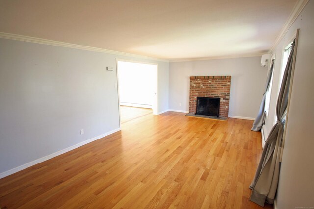 unfurnished living room featuring crown molding, baseboards, a brick fireplace, and light wood-type flooring