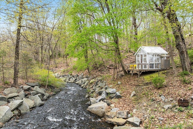 view of yard with a deck and a wooded view