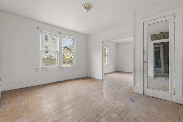 unfurnished room with baseboards and light wood finished floors