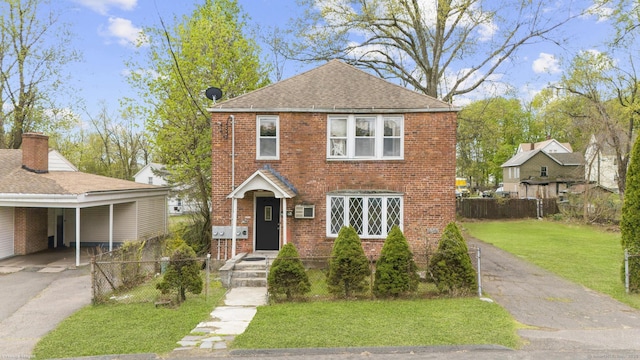 view of front of property with fence, driveway, brick siding, and a front yard