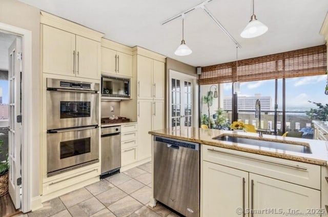 1 Gold St Unit 17De, Hartford, CT 06103 - kitchen featuring appliances with stainless steel finishes, a sink, cream cabinets, hanging light fixtures, and light tile patterned floors