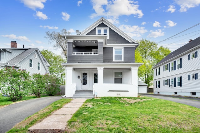 american foursquare style home with covered porch and a front lawn