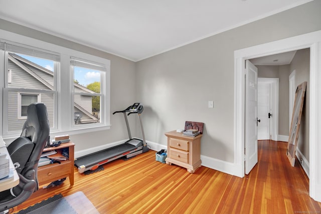 office space featuring baseboards, ornamental molding, and wood finished floors