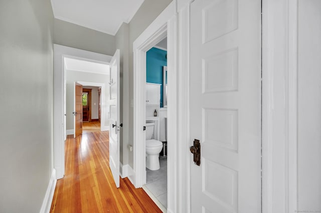 hall featuring light wood-style floors and baseboards