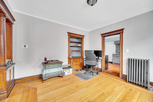 office space featuring baseboards, ornamental molding, radiator, and hardwood / wood-style floors