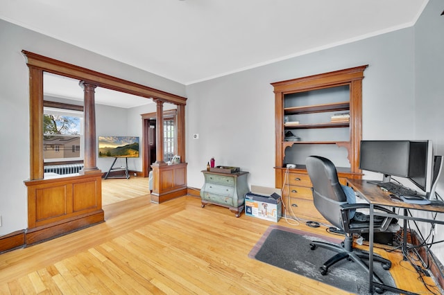 office featuring crown molding, baseboards, ornate columns, and wood finished floors