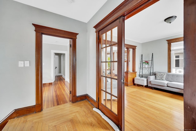 hallway with french doors, baseboards, and wood finished floors