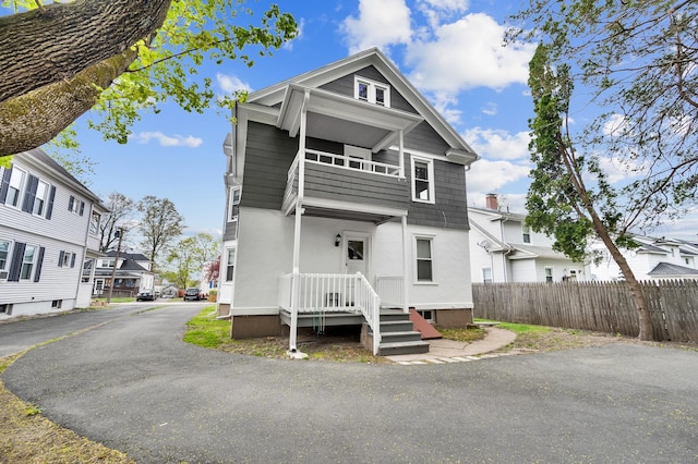 view of front facade featuring fence, a residential view, and stucco siding