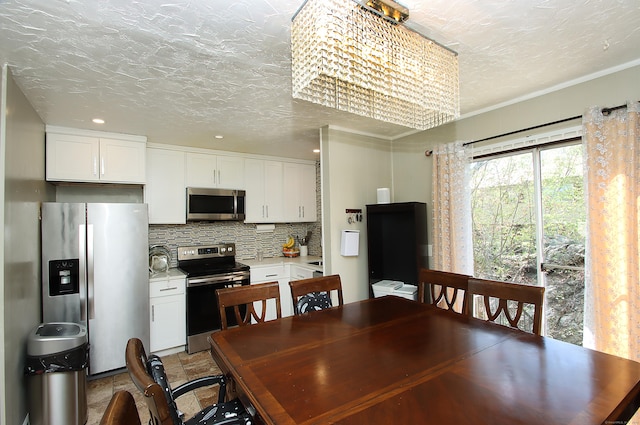 dining area featuring recessed lighting, a textured ceiling, an inviting chandelier, and ornamental molding