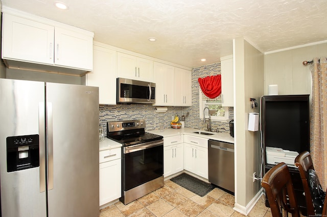 kitchen featuring a sink, appliances with stainless steel finishes, white cabinetry, and light countertops