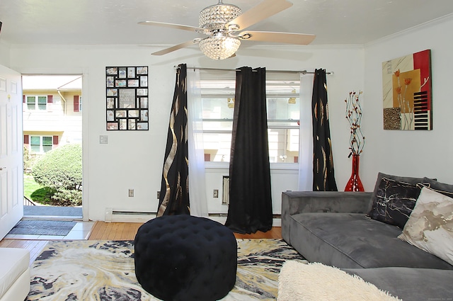 living room with plenty of natural light, crown molding, ceiling fan, and wood finished floors
