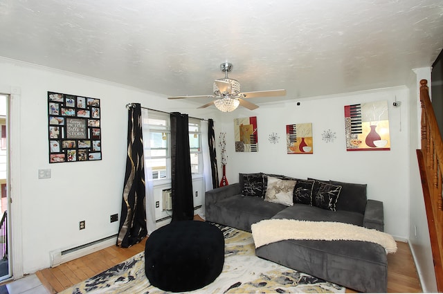 living room with crown molding, a ceiling fan, wood finished floors, and a baseboard radiator