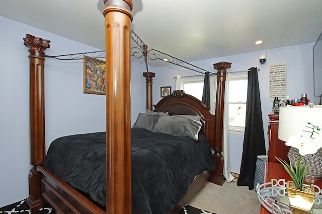 bedroom featuring light carpet and ornate columns