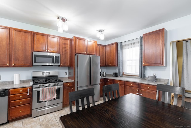 kitchen with light tile patterned floors, stainless steel appliances, light countertops, and brown cabinetry