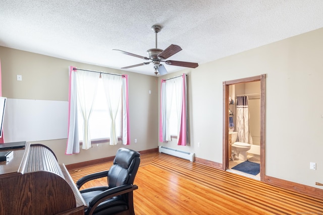 office featuring wood finished floors, a baseboard heating unit, baseboards, a ceiling fan, and a textured ceiling