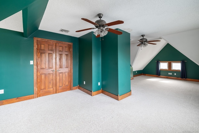 unfurnished bedroom featuring baseboards, visible vents, carpet flooring, and vaulted ceiling