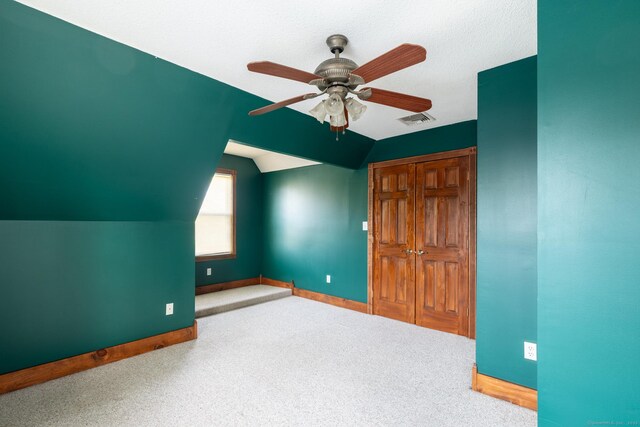 additional living space with a ceiling fan, visible vents, vaulted ceiling, and baseboards