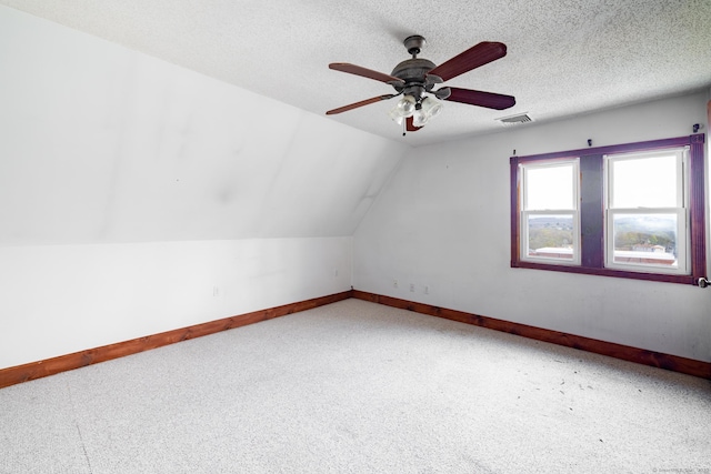 additional living space featuring vaulted ceiling, carpet flooring, baseboards, visible vents, and a ceiling fan