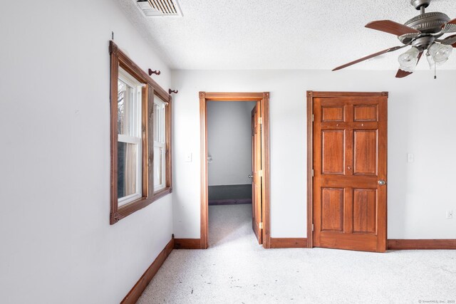 interior space with baseboards, visible vents, and a textured ceiling