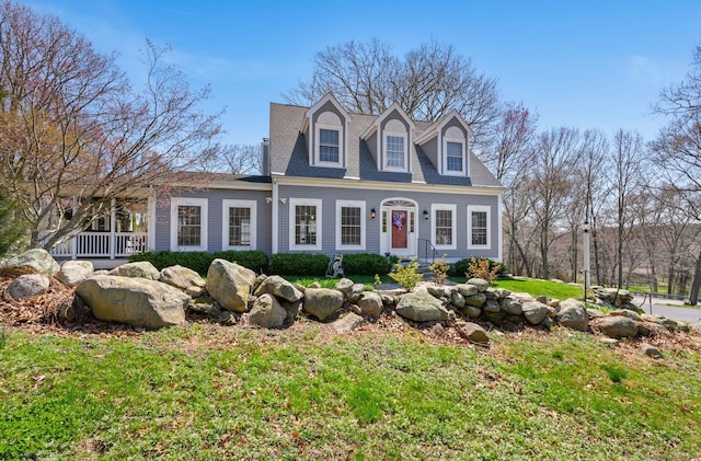 cape cod home with a shingled roof and a front yard