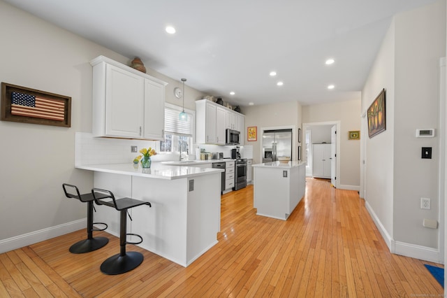 kitchen featuring a sink, appliances with stainless steel finishes, and light wood-type flooring